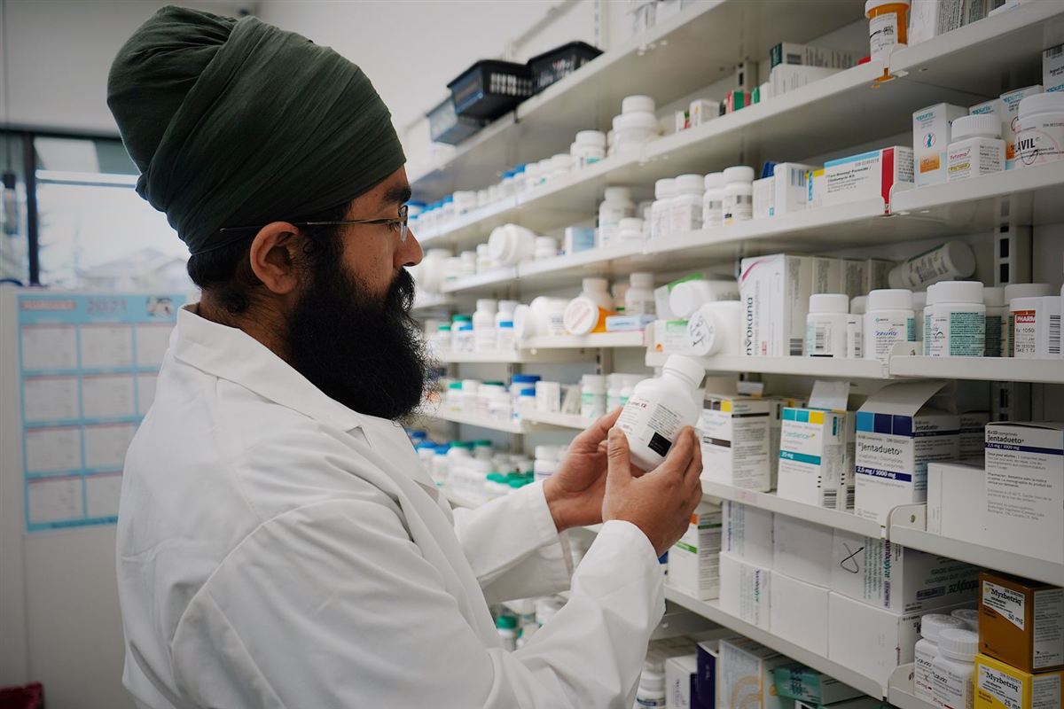 Pharmacist checking medicines on pharmacy shelves